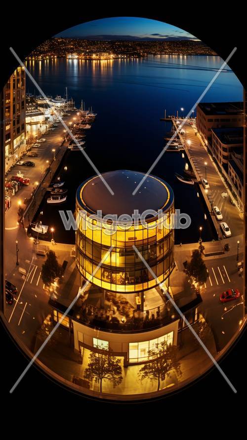 Świecący okrągły budynek przy porcie w nocy