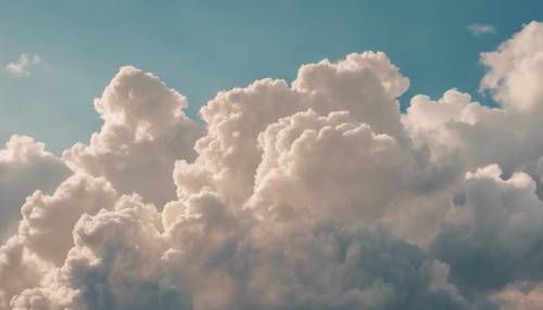 Spokojne beżowe chmury rozprzestrzeniają się po czystym, błękitnym porannym niebie.