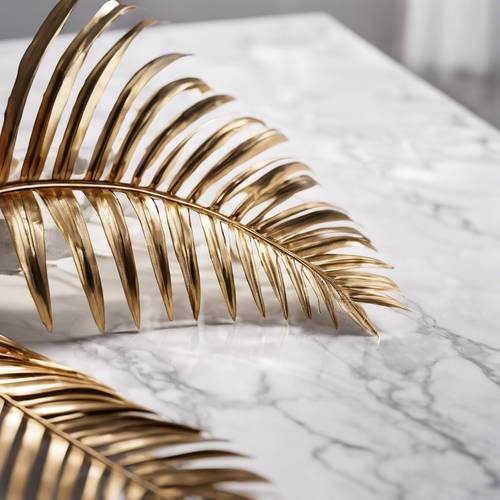 A softly lit still life image of a gold palm leaf lying on a marble white table.