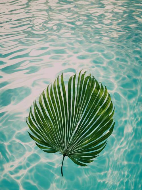 A palm leaf floating in a clear swimming pool, creating ripples around it.