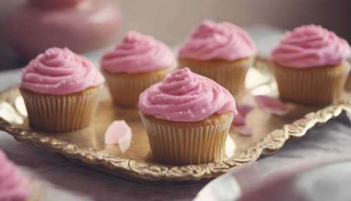 紙杯蛋糕上面舖有茂密的粉紅色天鵝絨糖衣，放在復古的盤子上。