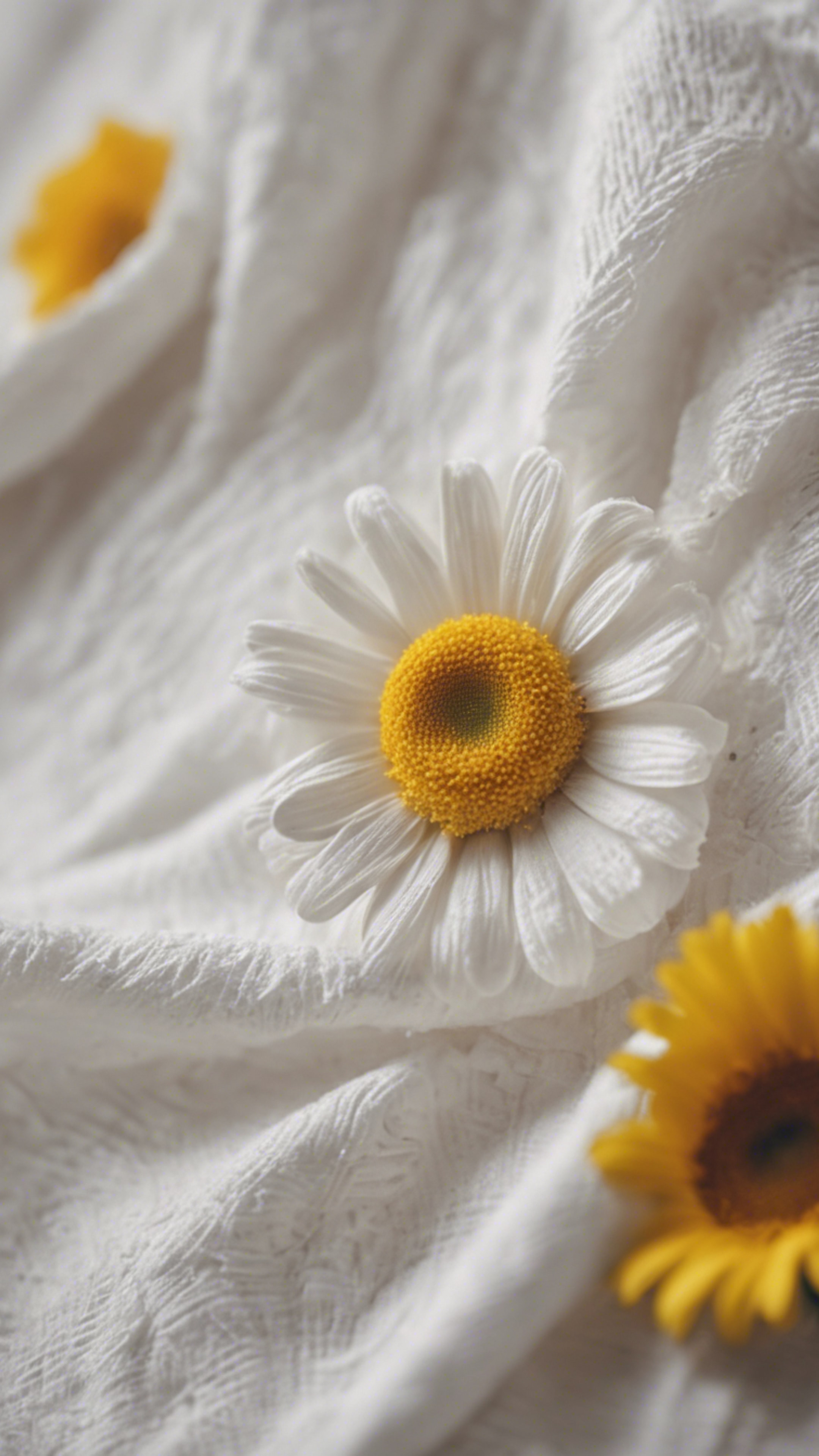 A white cotton dress with a daisy, featuring yellow petals and a white center. Tapeta[81c17e18773146008e6c]