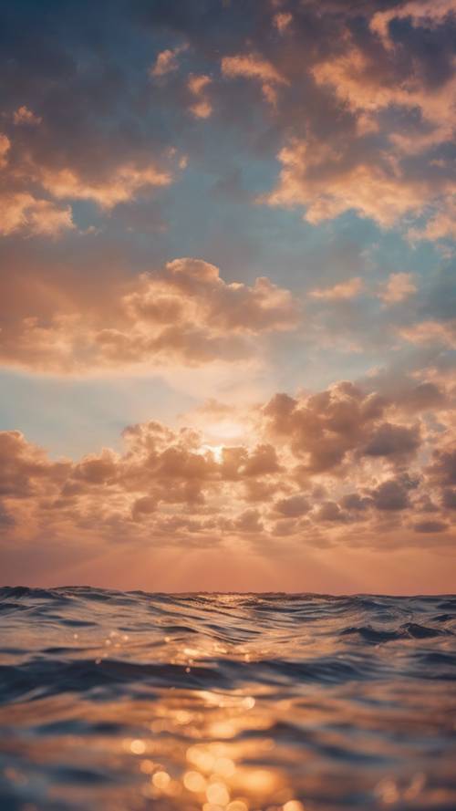 Skenario mimpi tentang lautan safir yang dalam bertemu dengan warna persik cerah di langit saat matahari terbenam.