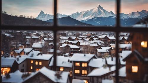 A rustic snowy skyline view of a toy-like mountain village seen through a window.