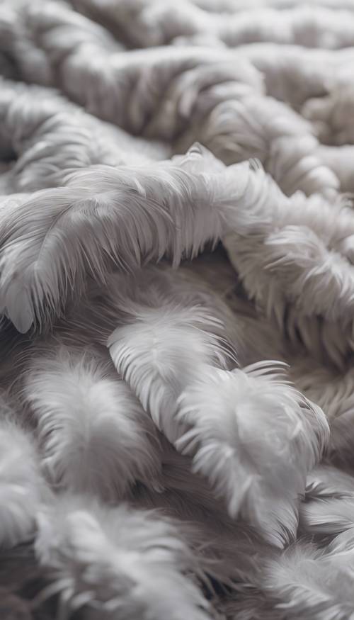 柔软、轻如羽毛的浅灰色羽绒毯子近距离展示着它的温暖和舒适。