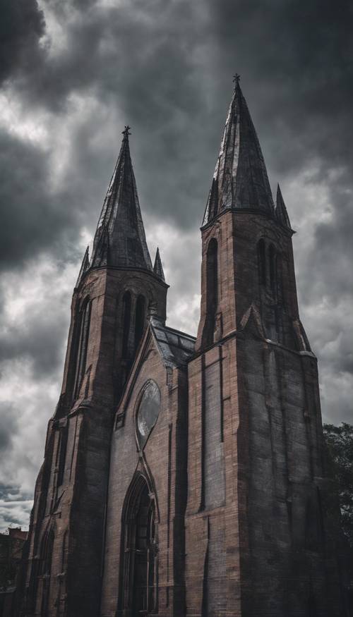 Bulutlu gökyüzünün altında gotik tarzda koyu gri tuğlalı bir katedral.