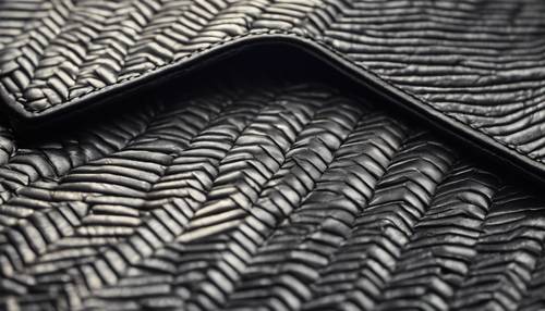 A close-up of a gray herringbone pattern on a leather wallet.