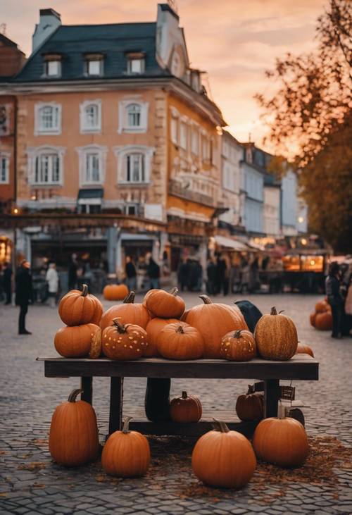 Sebuah kios labu di tengah alun-alun kota yang indah, tepat saat matahari terbenam pada malam Halloween.