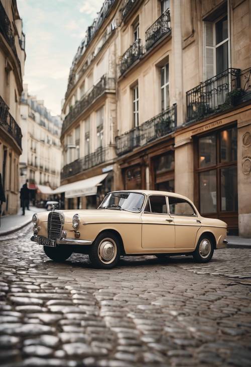 מכונית עתיקה חונה ברחוב מרוצף אבן בפריז.