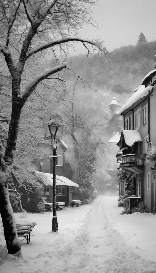 Una escena invernal nevada en un pueblo tranquilo representada en blanco y negro.