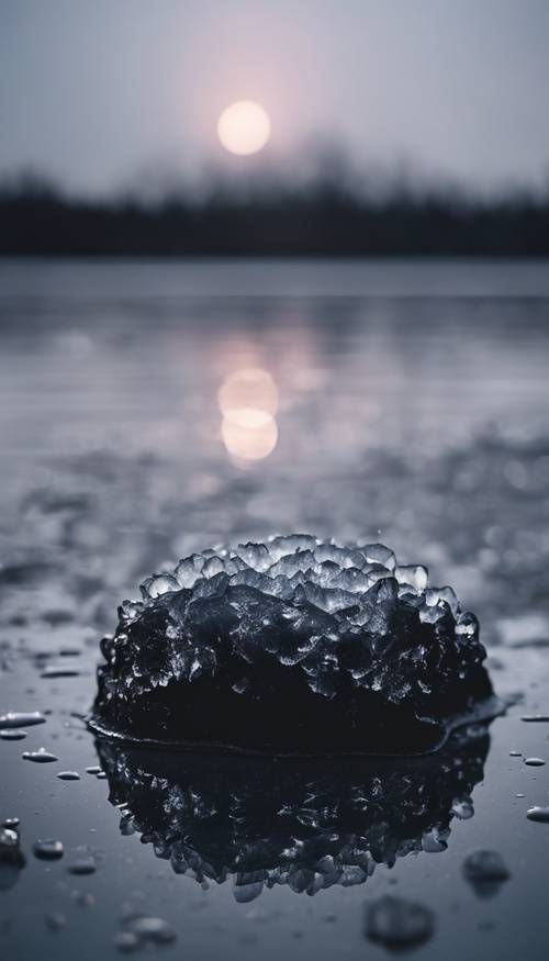 Gładka warstwa błyszczącego czarnego lodu pokrywająca powierzchnię spokojnego jeziora pod nocnym niebem.
