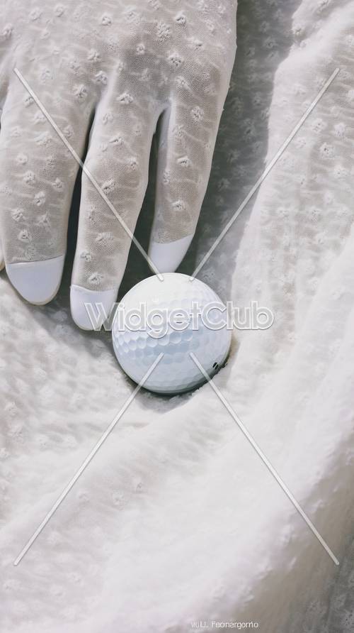 Pelota de golf y guantes elegantes sobre tela suave