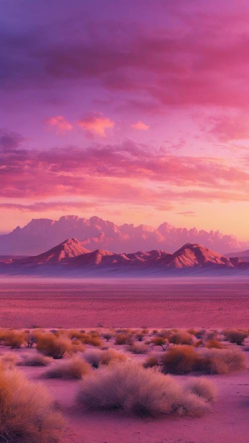 Ein farbenfroher Sonnenaufgang, der den Himmel über einer großartigen Wüstenlandschaft in Rosa-, Gold- und Violetttönen bemalt.