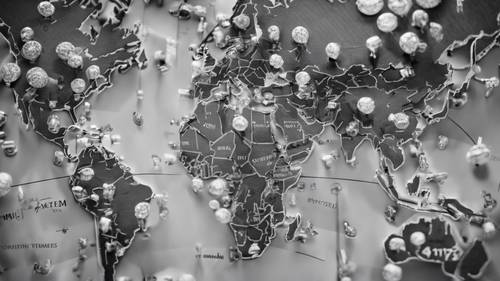 A grayscale world map marked with pins displaying visited places. Tapet [0264905edac74796836e]