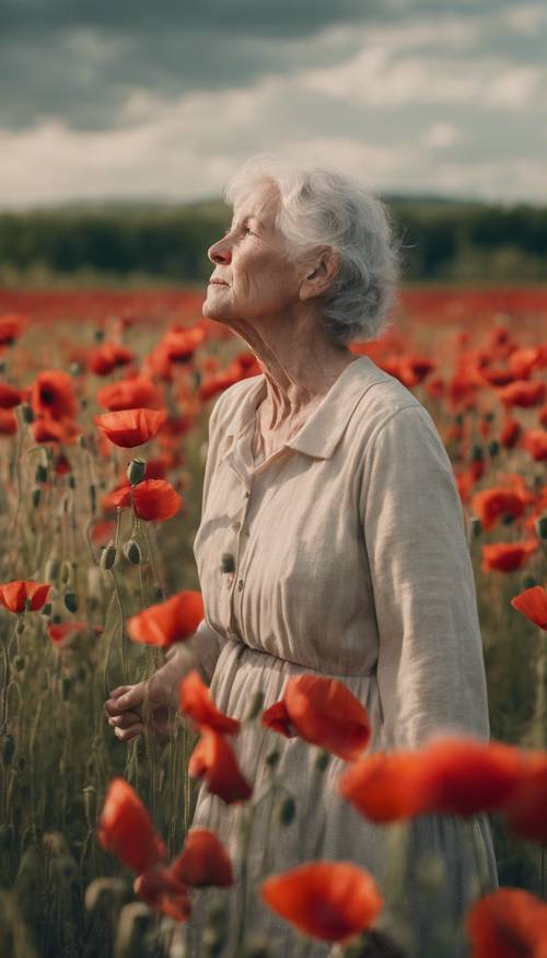Kırmızı gelinciklerle dolu bir tarlada duran ve yumuşak yaprakları hisseden yaşlı bir kadın.