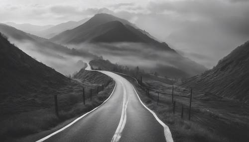 A long, winding black and white striped road disappearing into misty mountains.