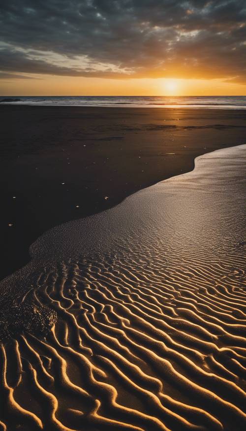 Eine Weitwinkelaufnahme eines schwarzen Sandstrandes mit goldenem Sonnenuntergang.