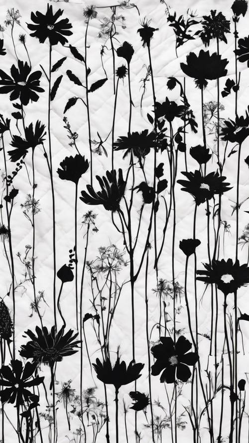Black silhouettes of wildflowers outlined on a snow-white quilt.