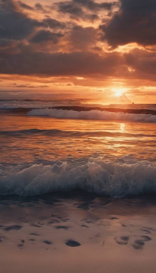 Ekscytujący zachód słońca na plaży z ciemnym ombre przechodzącym od głębokiego granatu do delikatnej pomarańczy, odbijającym się w uspokajających falach oceanu.