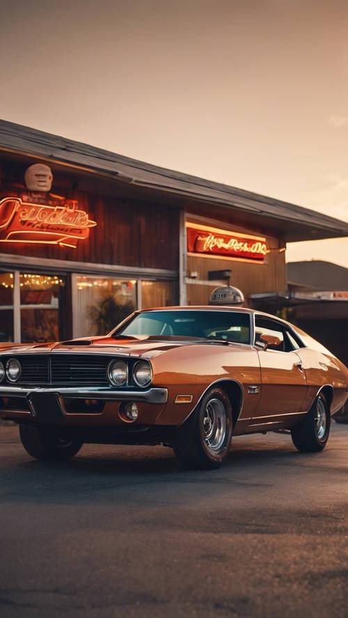 Klasyczny muscle car z lat 70. zaparkowany przy przydrożnej restauracji o zachodzie słońca.