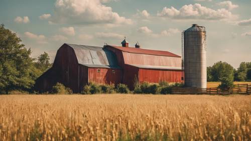A vibrant rural scene with a barn and silo under the summer sky.