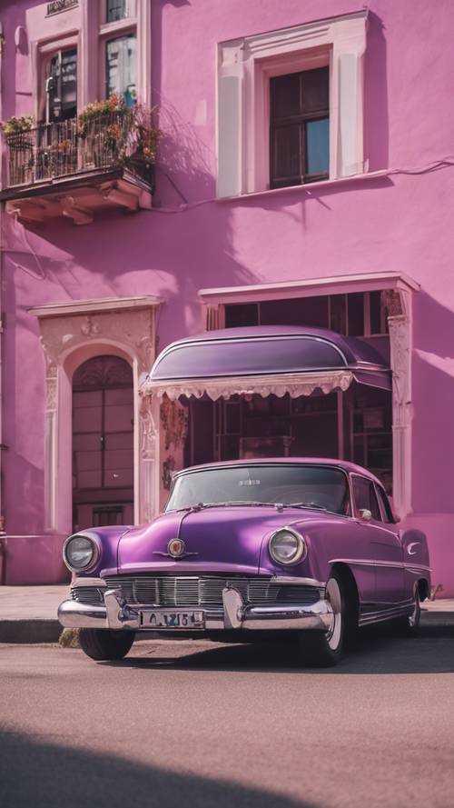 一辆紫色的老式汽车停在一栋粉红色的建筑旁边。