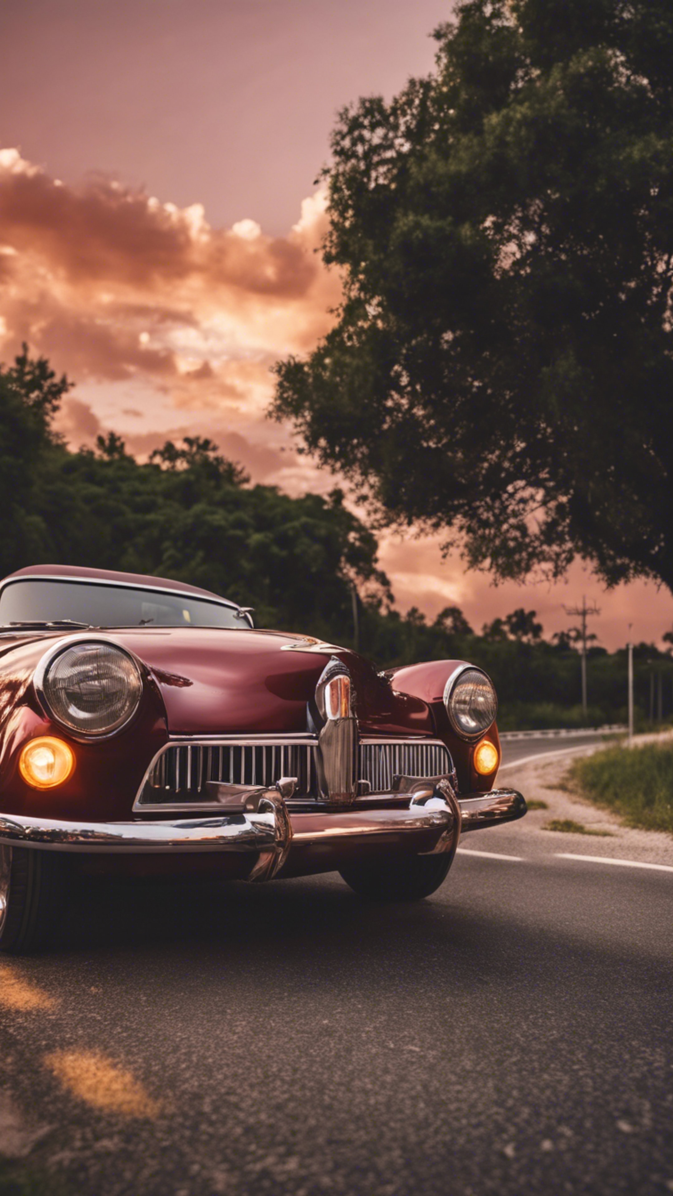 A cool maroon vintage car cruising down a highway during sunset.壁紙[f4173fef60b3476589ab]