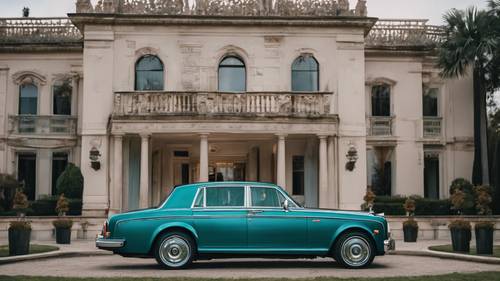 Un Rolls Royce verde azulado estacionado afuera de una gran y ornamentada mansión.
