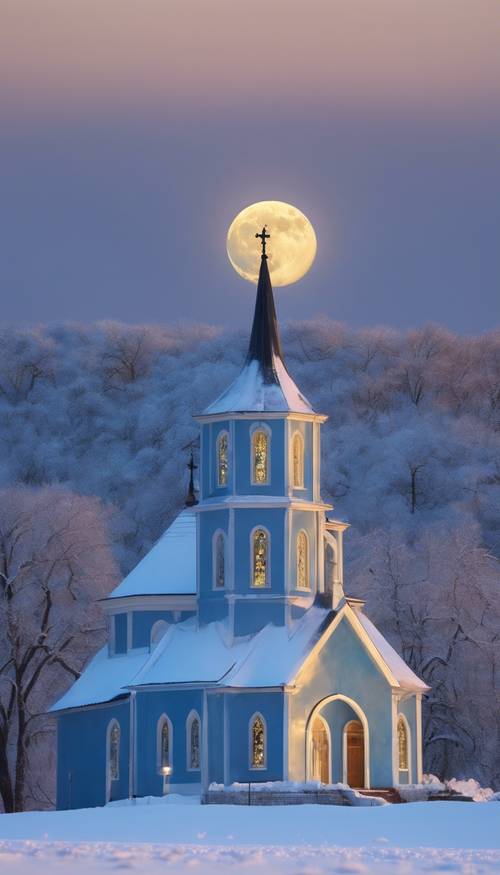 A tranquil blue church nestled in a snow-covered landscape during a serene winter evening with the moon illuminating from the background.