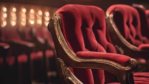 Yumuşak, sıcak bir spot ışığının altında bir çift antika kırmızı kadife kaplı tiyatro koltuğu.