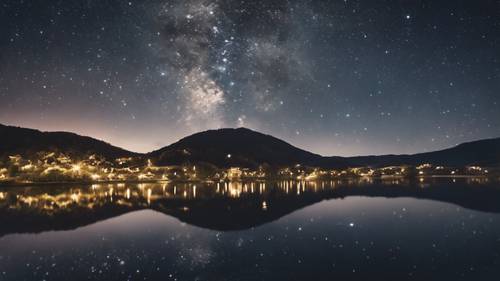 Distant village on the foothills of a mountain, mirror reflecting in a calm lake under a starry night sky.
