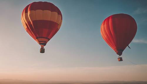 Um balão de ar quente vermelho navegando no céu azul claro durante o pôr do sol.