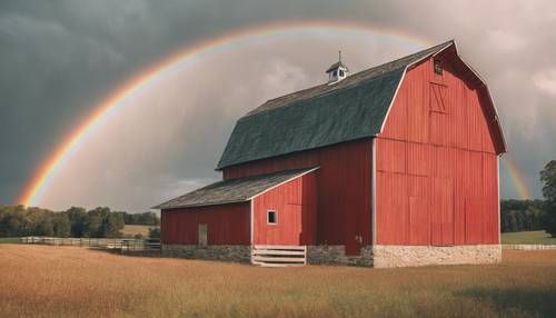A red barn on a farm under a sky with a pastel neutral colored rainbow.