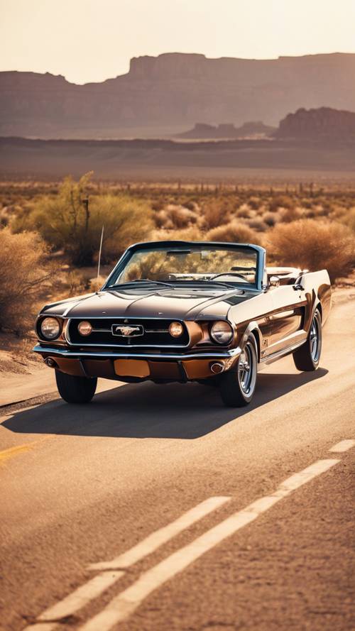 Una classica Mustang decappottabile che percorre la Route 66 al tramonto con uno splendido scenario desertico sullo sfondo.