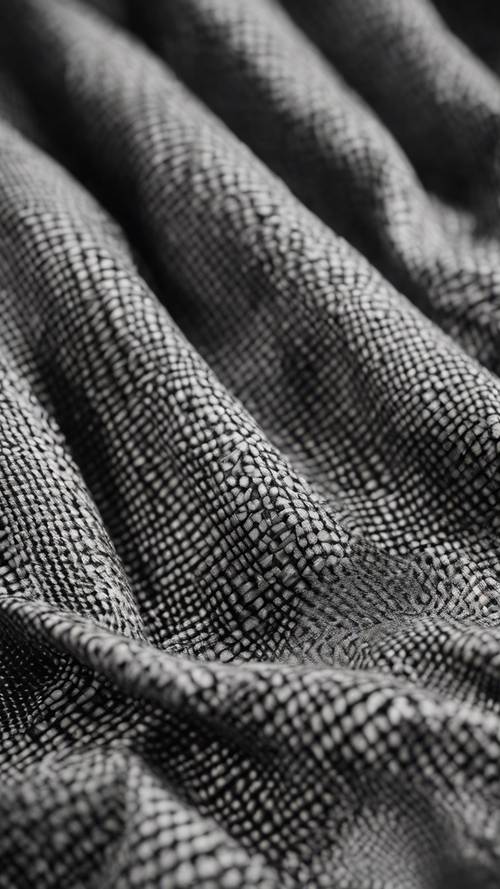 A closeup of a black and grey plaid fabric with geometric patterns.