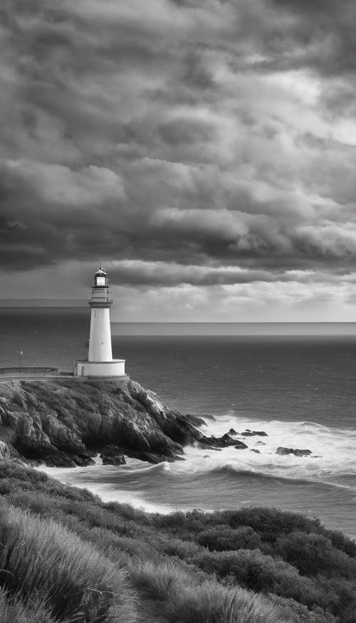 Una vista dell&#39;orizzonte dell&#39;oceano sotto un cielo nuvoloso, un faro solitario su una scogliera vicina, l&#39;immagine in bianco e nero.