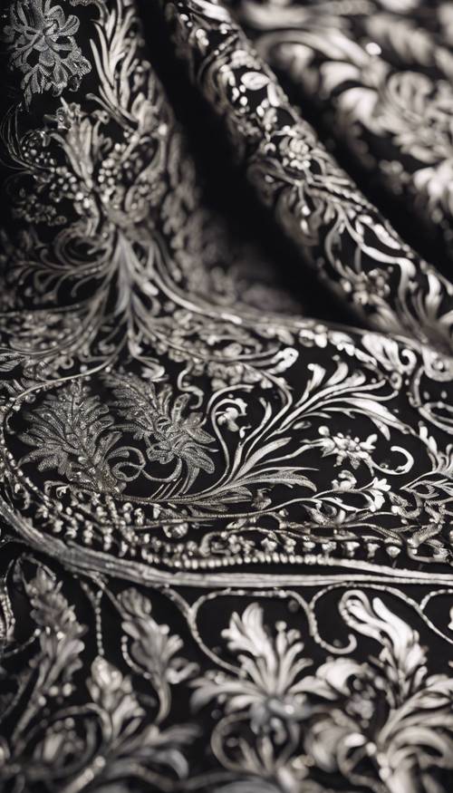 近距离观察黑色和银色锦缎织物，重点关注复杂的设计细节。