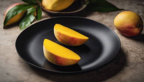 多汁的黄色芒果片排列在现代、光滑的黑色盘子上。