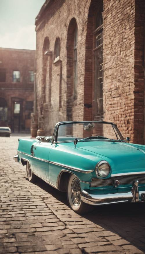 Eski bir tuğla duvarlı binanın önüne park edilmiş vintage turkuaz araba.