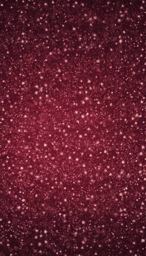 A wallpaper pattern with an ombre effect of burgundy glitter.