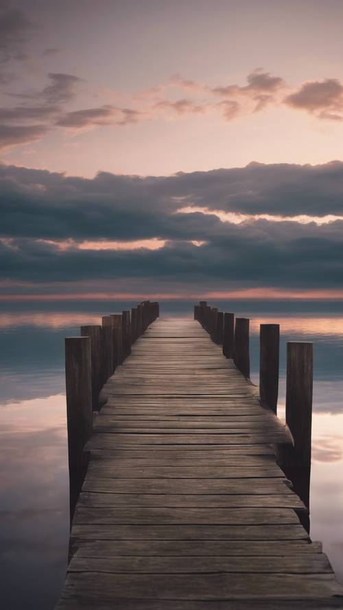 Um antigo cais de madeira rústico que se estende até um lago sereno que reflete o céu ao entardecer.
