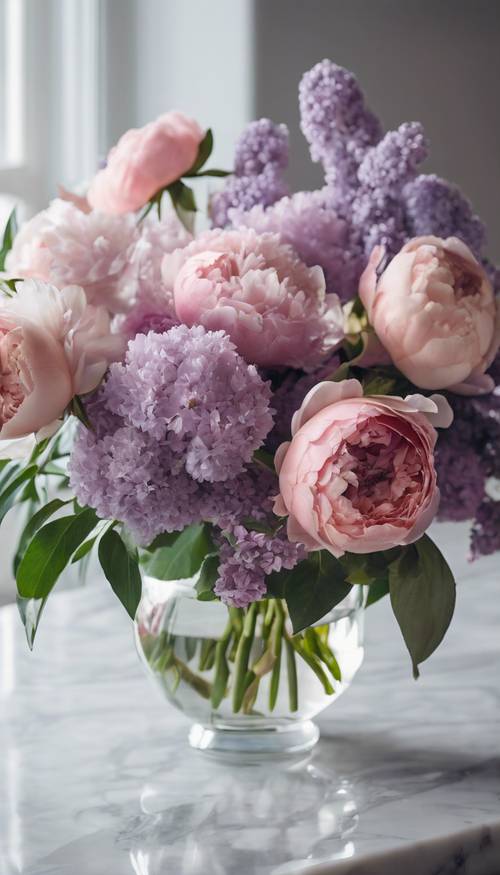 Un bouquet de roses fraîches, de pivoines et de lilas dans un vase en cristal sur une table en marbre.