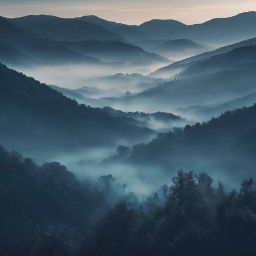 Nebbia blu scuro che si diffonde su una tranquilla valle di montagna