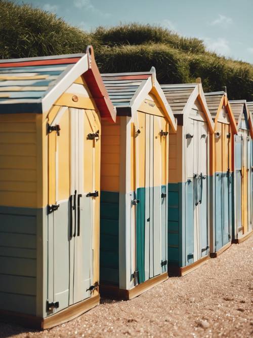 Uma fileira de cabanas de praia pintadas banhadas pelo sol quente de julho.