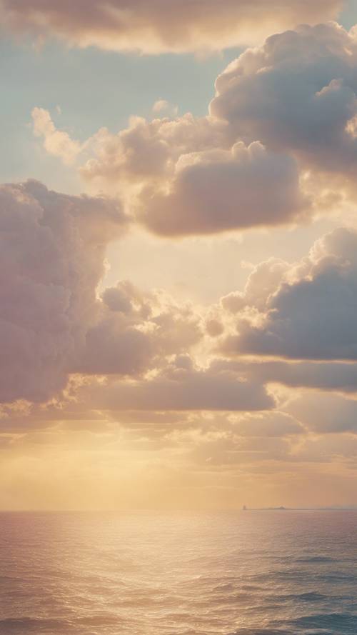 Soffici nuvole alla deriva attraverso un cielo giallo pastello all&#39;alba.