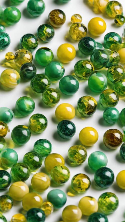 A set of green and yellow marbles scattered on a white background.