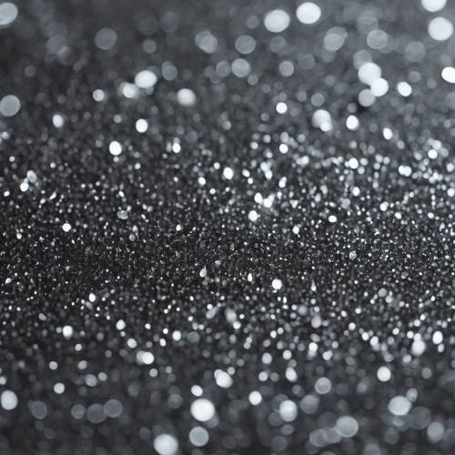 The texture of a deep gray glittery surface, finely milled and captured under soft natural light.