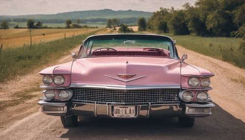 A vintage pink Cadillac in pristine condition, driving down a picturesque countryside route. Tapeta [251ec094533e41f39641]