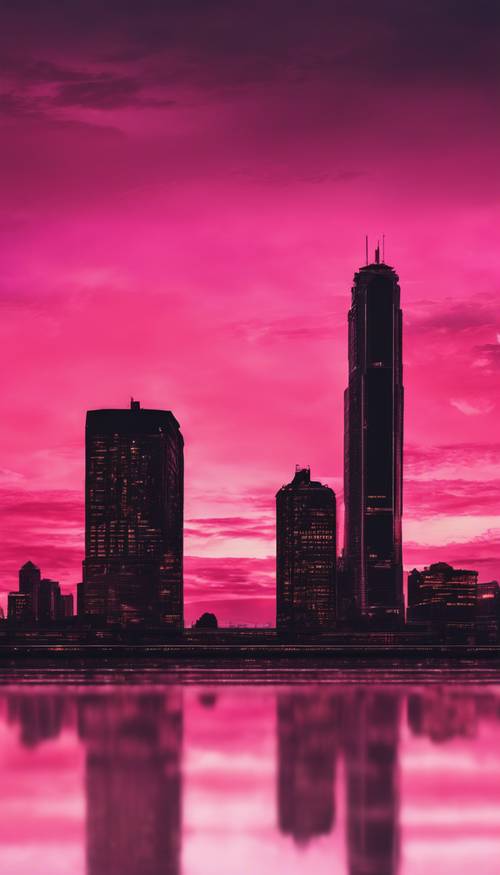 Un tramonto con un cielo rosa vivido e la sagoma nera dello skyline di una città.