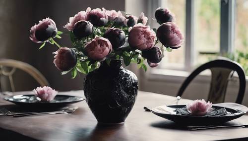 Un jarrón decorado con peonías negras sobre una mesa de comedor.